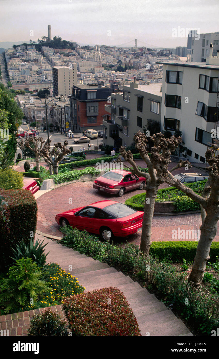 Zeigen Sie auf LOMBARD Straße mit COIT TOWER und BAY BRIDGE im Hintergrund - SAN FRANCISCO, Kalifornien an Stockfoto