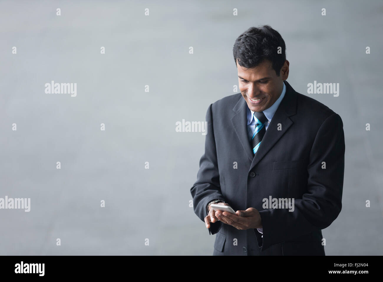 Vogelperspektive Blick auf ein indischer Geschäftsmann vor modernen Bürogebäude. Asiatische Geschäftsmann lächelnd. Stockfoto