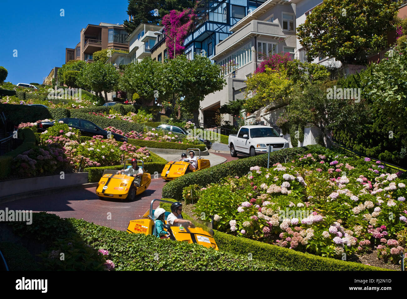 Touristen gehen Autos mieten und genießen Sie die Drehungen und Wendungen der LOMBARD STREET, SAN FRANCISCO, Kalifornien Stockfoto