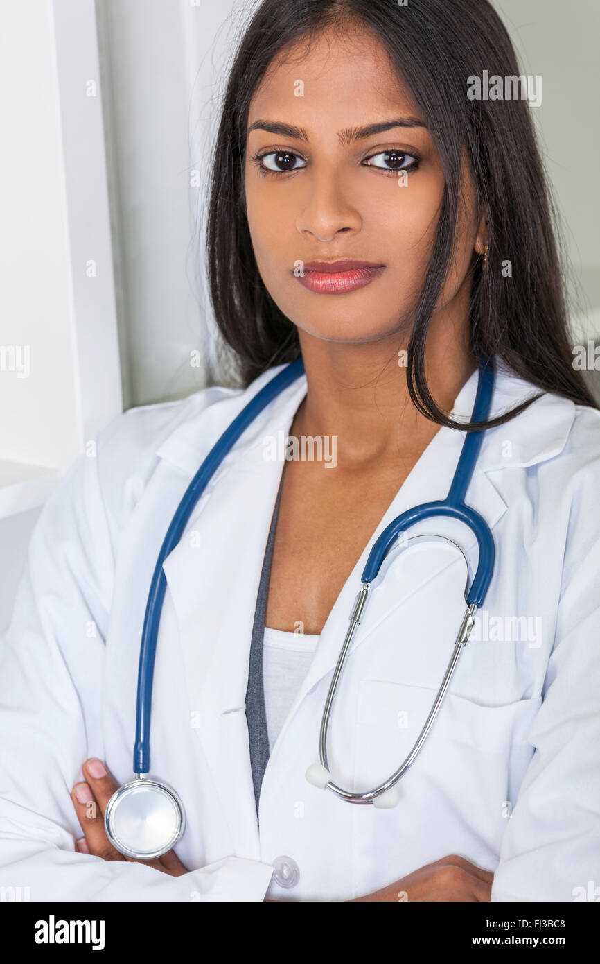 Eine nachdenkliche indische asiatischen weiblichen Arzt Arme verschränkt in einem Krankenhaus-Büro mit Stethoskop Stockfoto