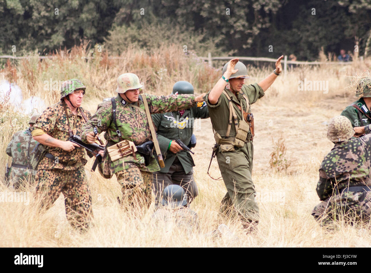 Zweiten Weltkrieg scheingefecht Re-enactment. Deutsch Sturm Truppen in der Tarnung Uniform, die amerikanischen Panzer crewman, mit erhobenen Händen, gefangen. Stockfoto