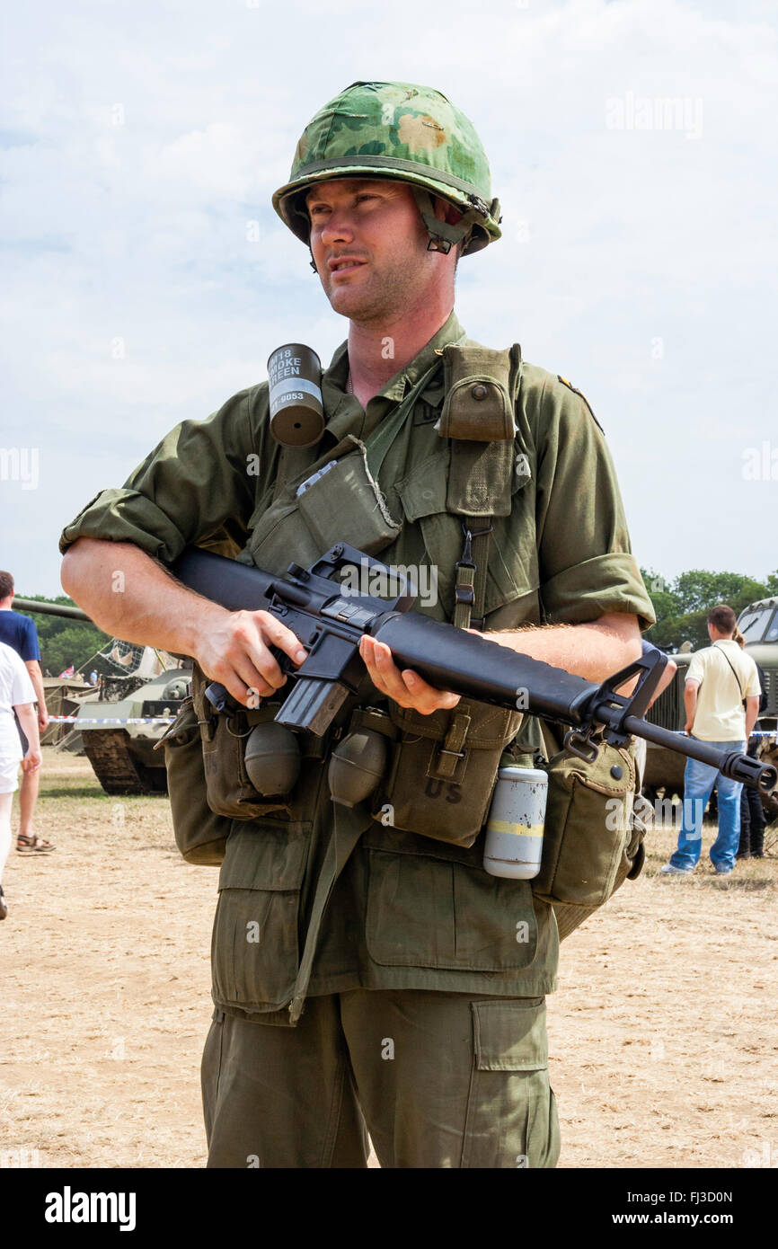 Vietnam Krieg Re-enactment. Amerikanischer Soldat auf Wache im Sonnenschein holding M 16 Gewehr, und zwei Kantinen hängen vom Riemen. Stockfoto