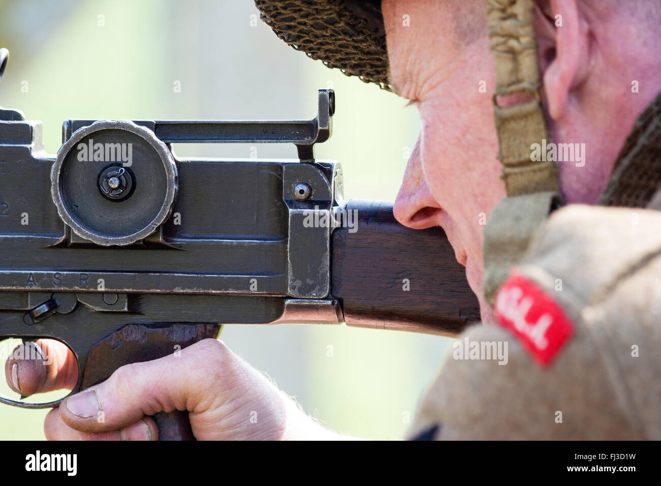 Weltkrieg zwei Re-enactment. British King's Shropshire Licht Infanterist zur Festlegung und die darauf abzielen, die Bren gun. Nahaufnahme des Gesichts- und Teil der Pistole. Von der Seite. Stockfoto