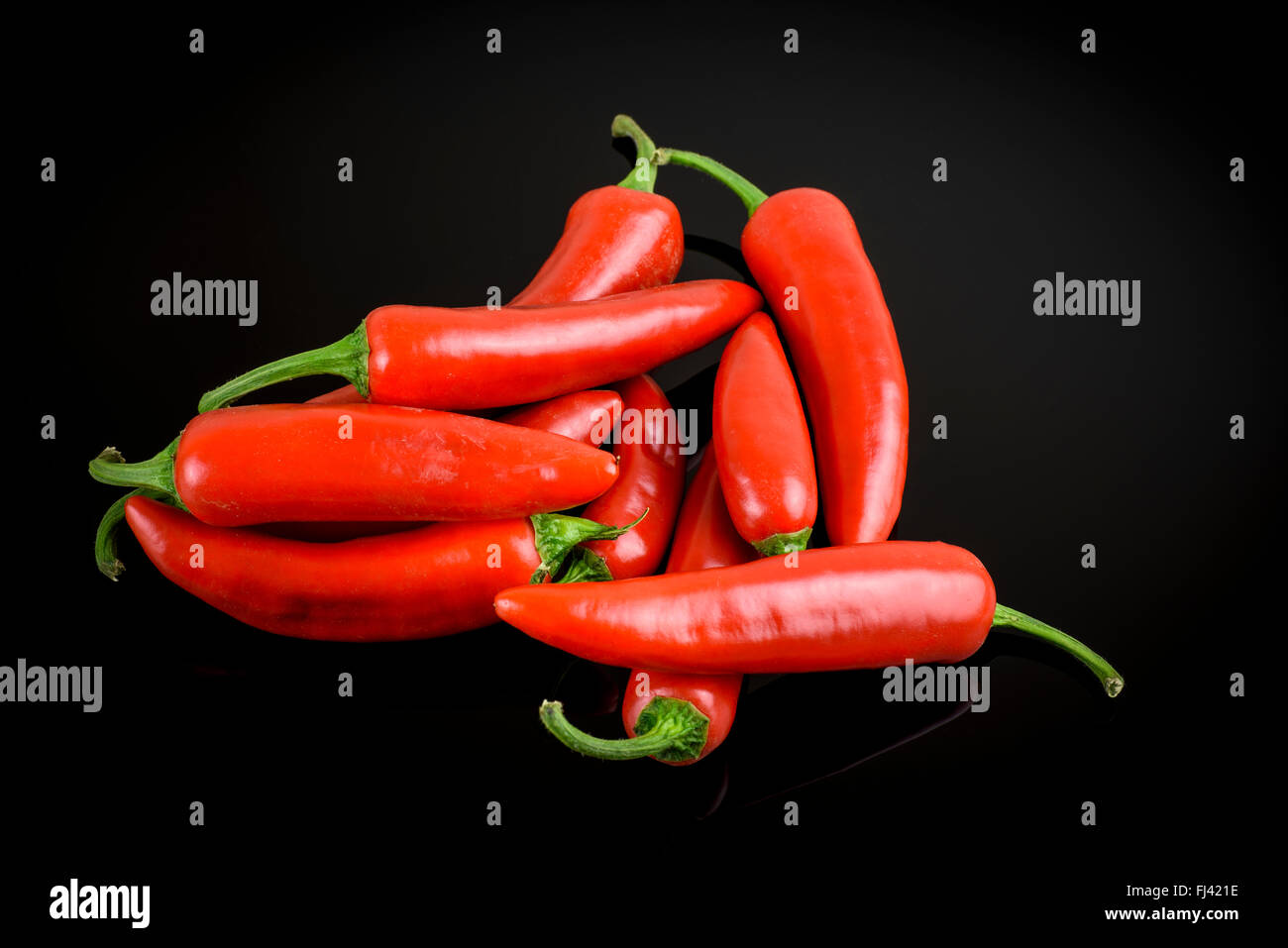 Gruppe von frische ganze Red Hot Chili auf schwarzem Hintergrund Stockfoto
