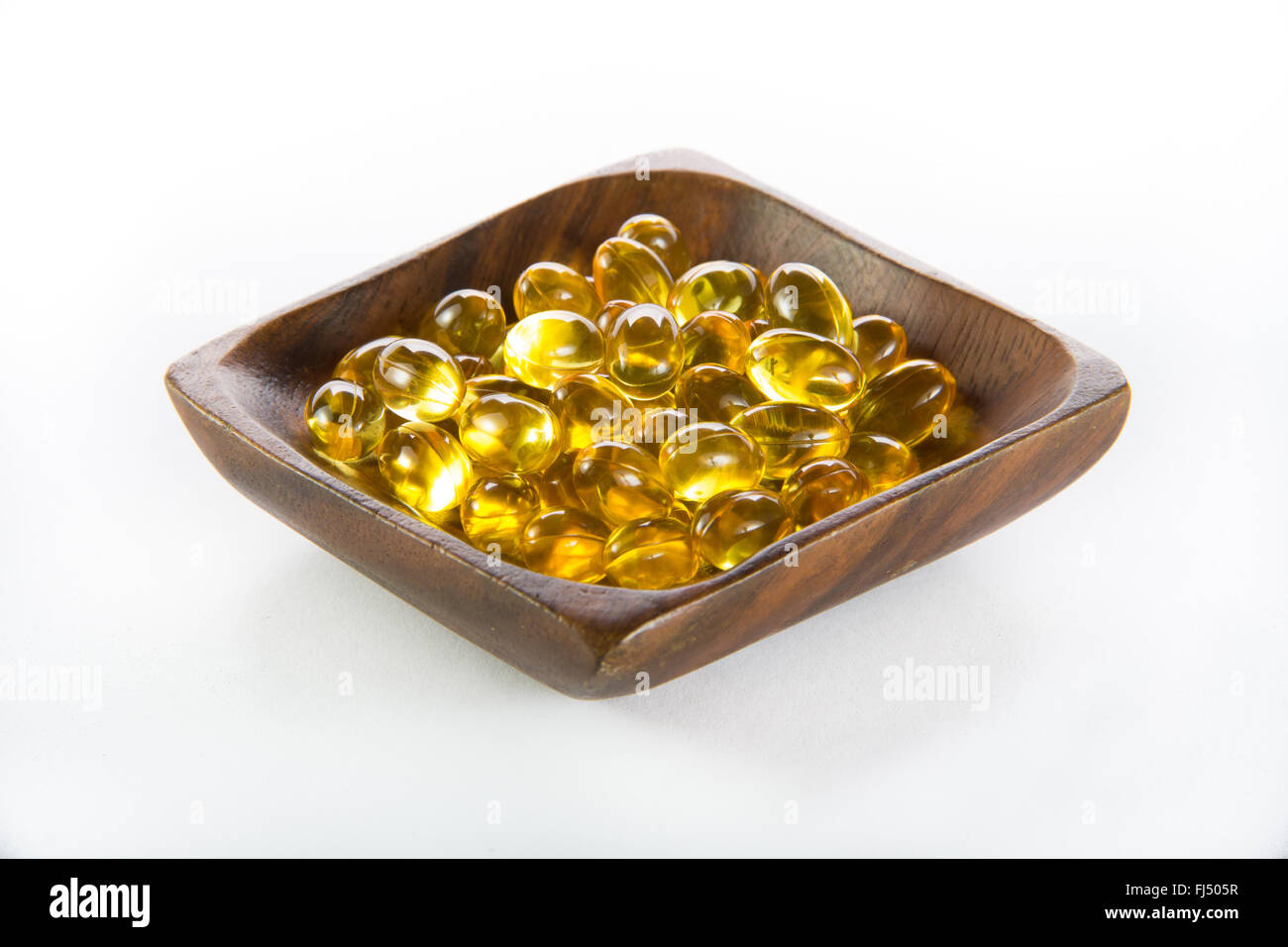 Lebertran, Omega 3, Vitamin D-Kapseln in Holzschale Stockfoto