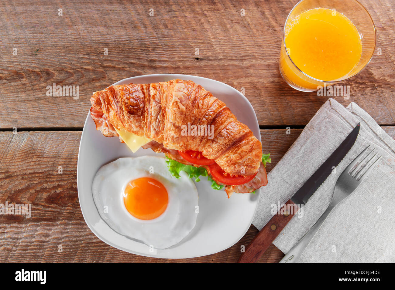 Sandwich-Croissant mit gebratenem Speck Käse Tomate Frühstück und Ei Stockfoto