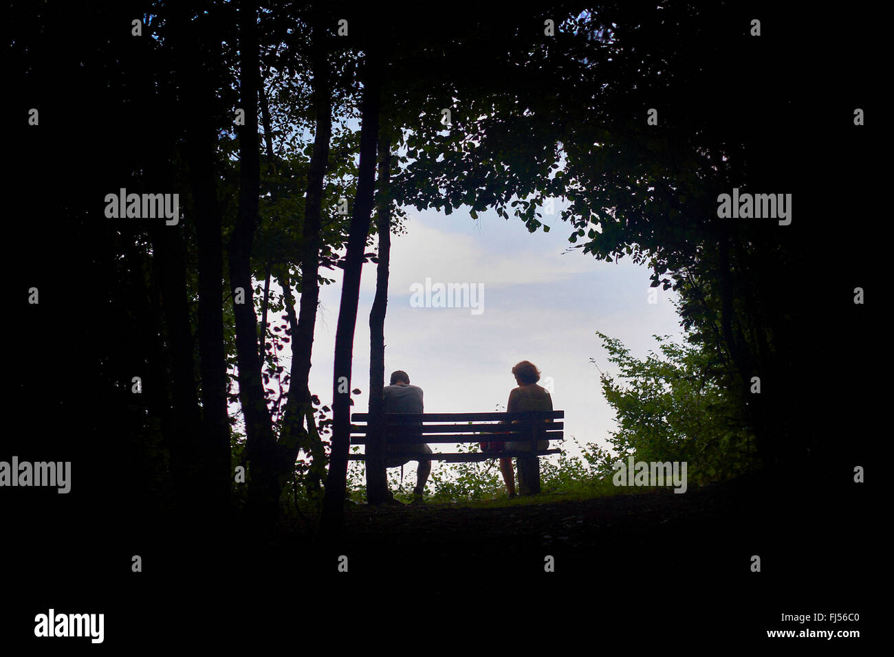 Mann und Frau sitzen auf einer Bank am Ende einer langen und beschwerlichen Reise, Volme Hoehenring, Germany, North Rhine-Westphalia Stockfoto