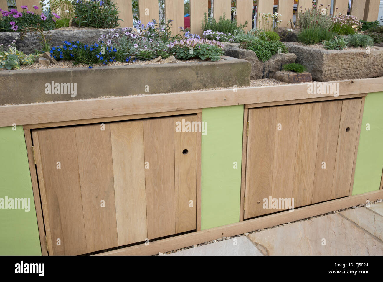 Terrasse mit einem Steingarten mit alpinen Pflanzen Pflanze in Steinbehältern Container Trog Bank mit Aufbewahrungsschränken - Frühling UK Stockfoto