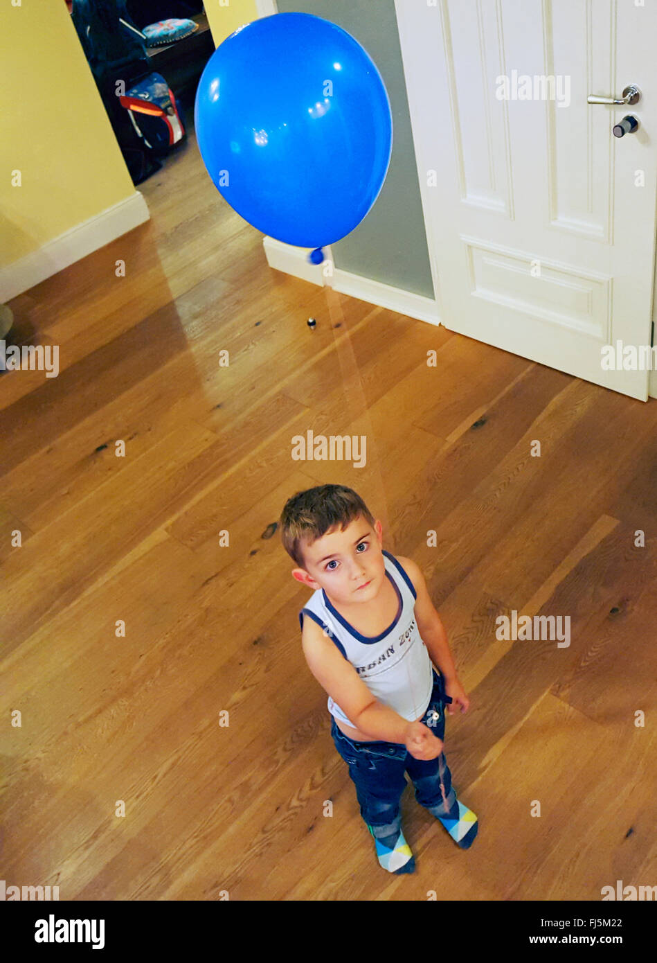 kleiner Junge mit blauen Luftballon Stockfoto