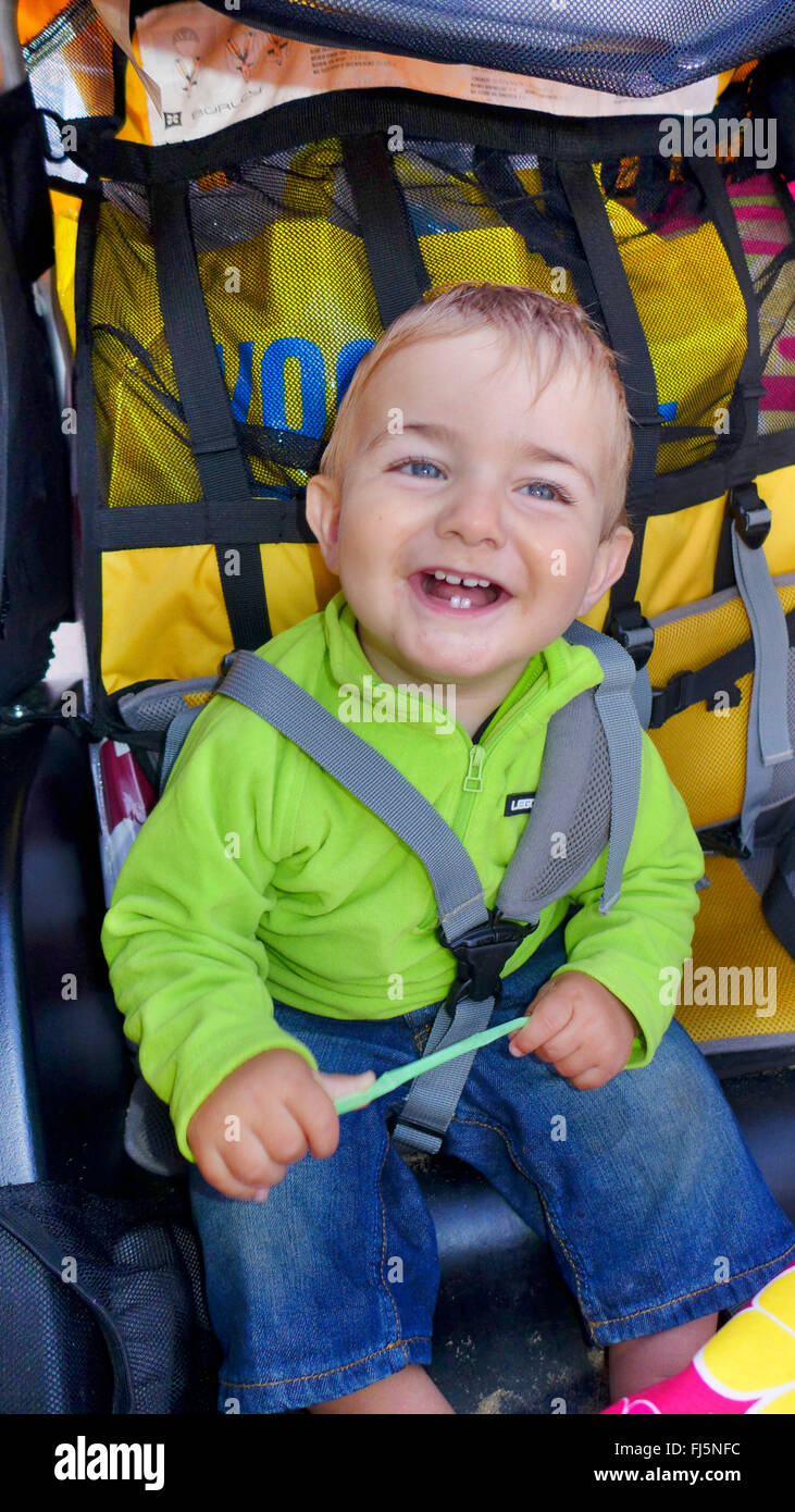 glückliche kleine Junge in einem Buggy sitzend und lachend, Niederlande Stockfoto