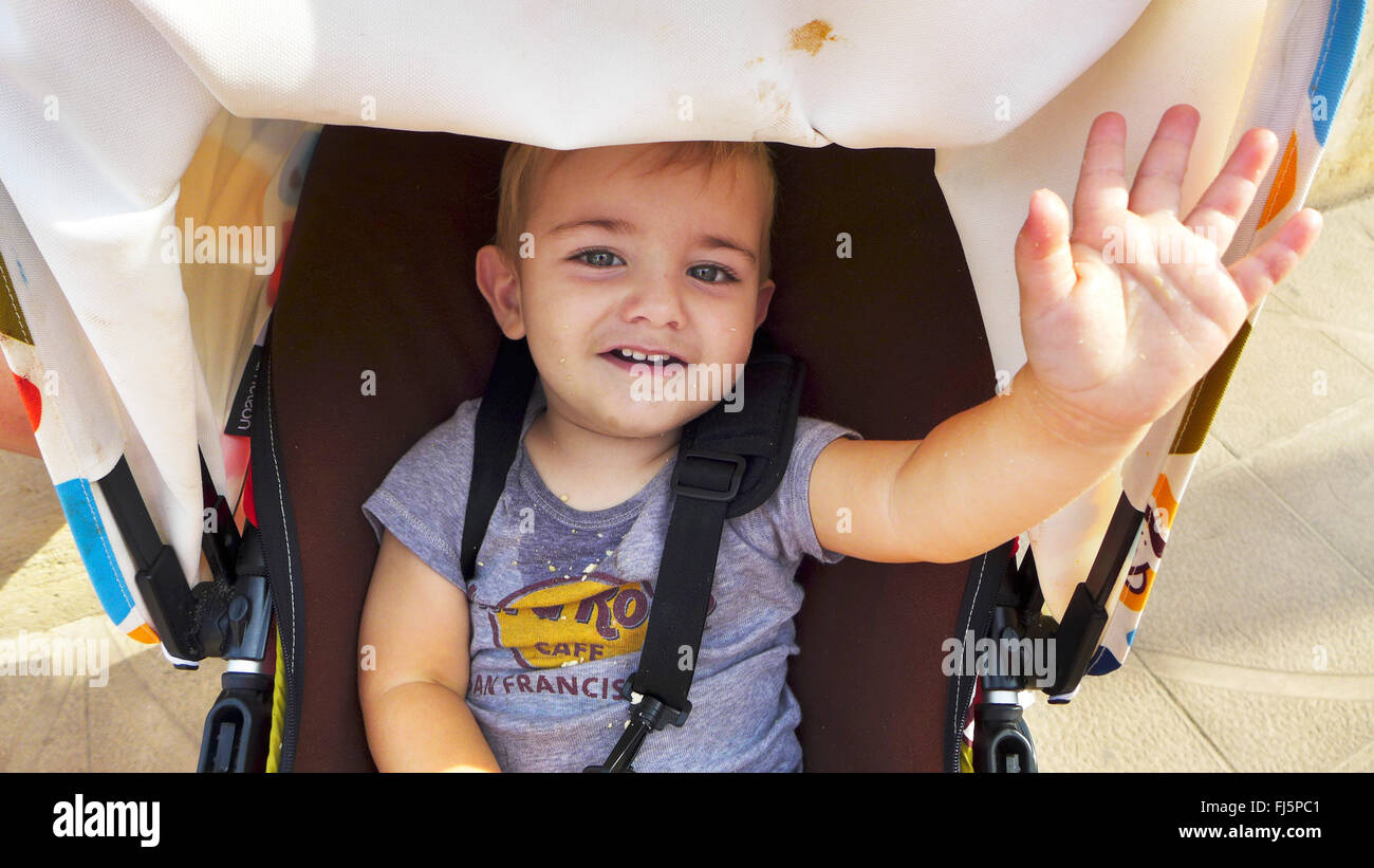 glücklich kleiner Junge sitzt in einem Buggy und winken, Porträt eines Kindes, Niederlande Stockfoto