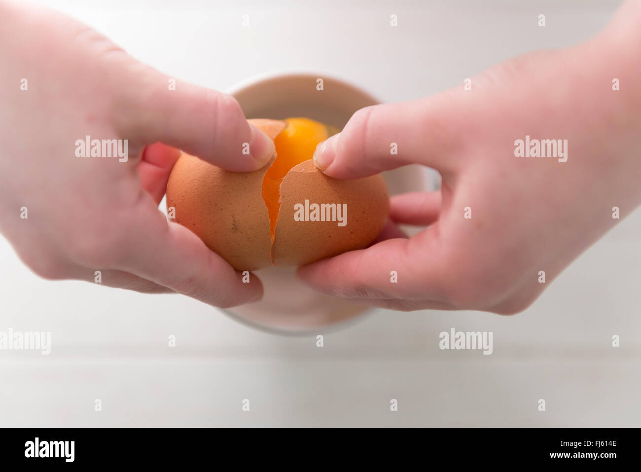 Ein Koch, eine Freilandhaltung Ei in einer Schüssel zu knacken. Stockfoto