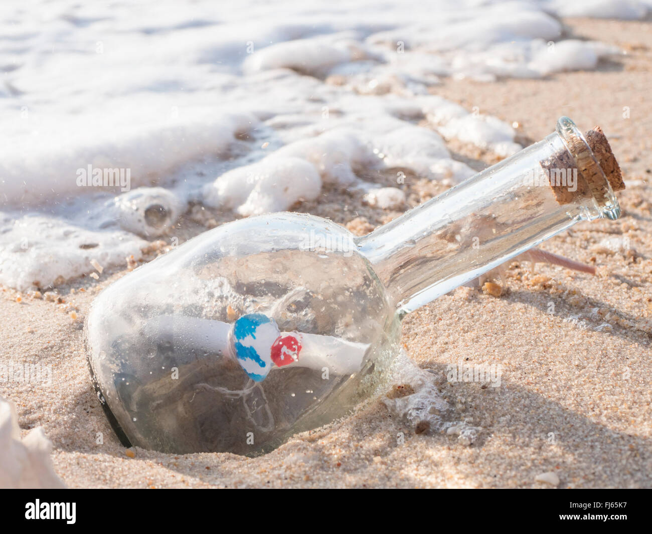 Nachricht in der Flasche, Symbol Benachrichtigung, die selektiven Fokus auf die Nachricht in der Flasche mit dem Meer und Blase Welle Stockfoto