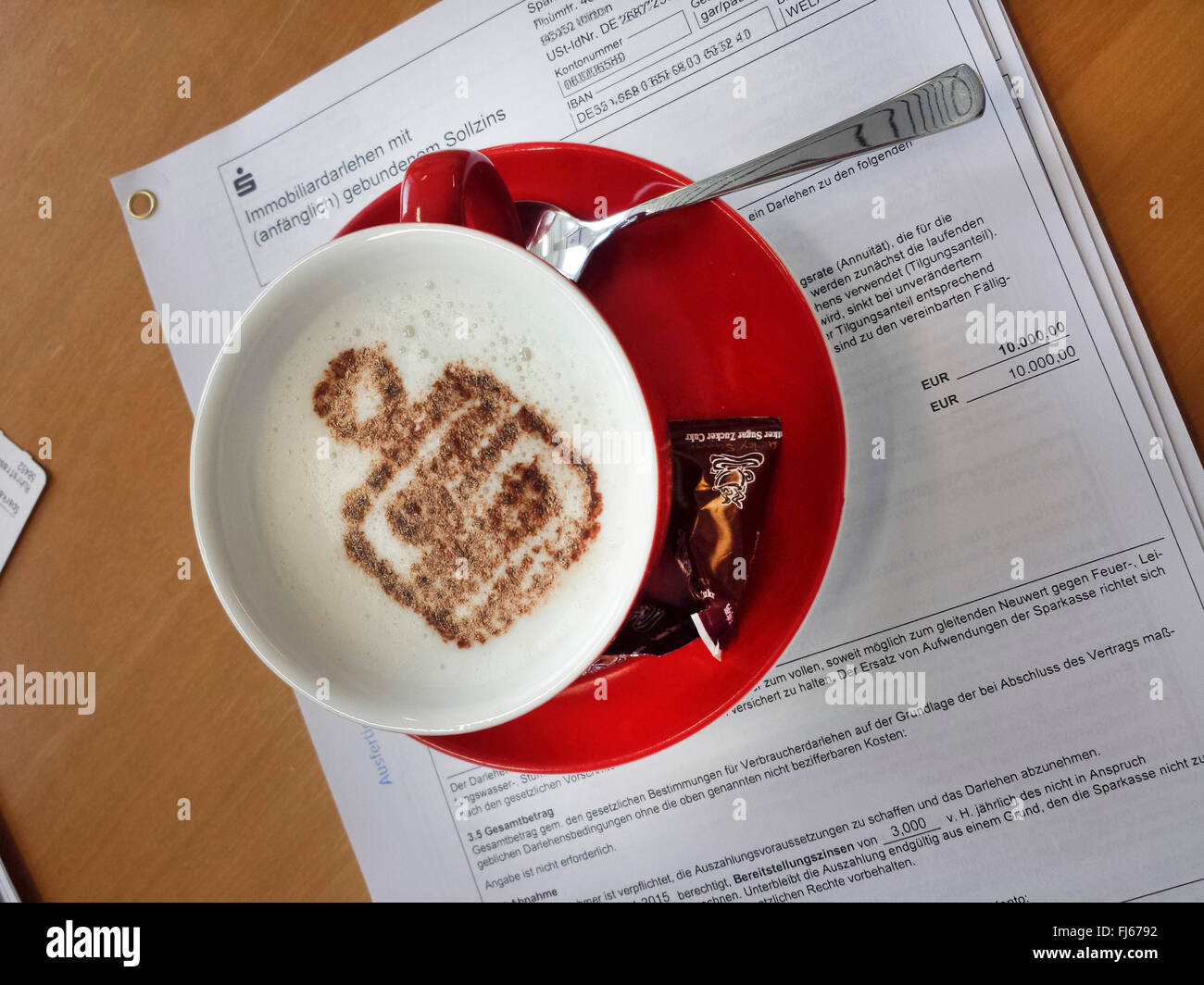 Cappuccino mit Symbol einer Sparkasse auf Darlehensvertrag, Deutschland Stockfoto