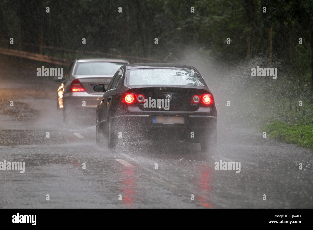 Autos auf der überfluteten Straße bei starkem Regen, Deutschland Stockfoto