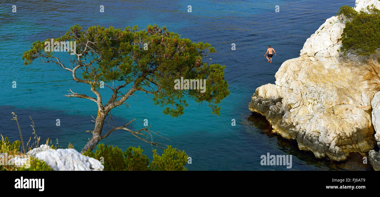Mann springt aus dem Gestein der Calanque de Sormiou ins Meer, Marseille, Frankreich, Calanques Nationalpark Stockfoto