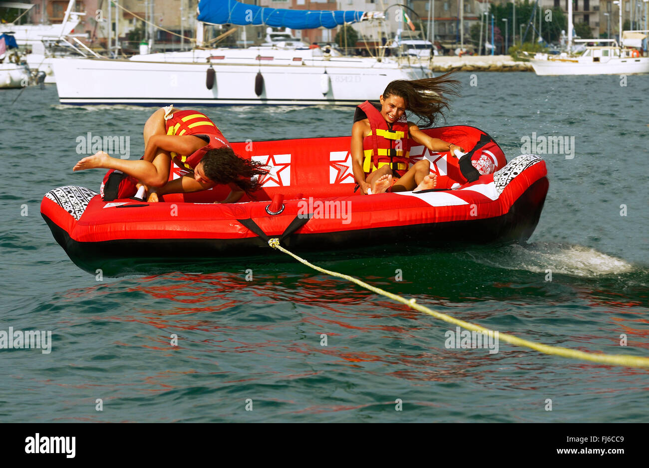 zwei Mädchen sind über dem Wasser mit einem Luft-Couch, Frankreich, Corsica gezogen werden Stockfoto