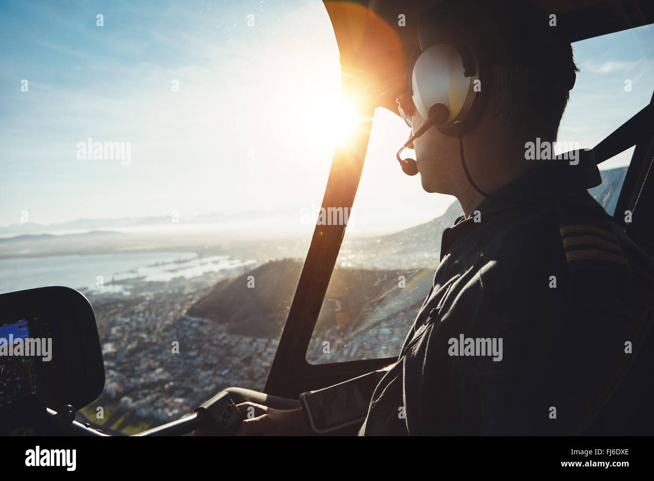 Nahaufnahme eines Hubschrauberpiloten fliegen Flugzeuge über eine Stadt an einem sonnigen Tag Stockfoto