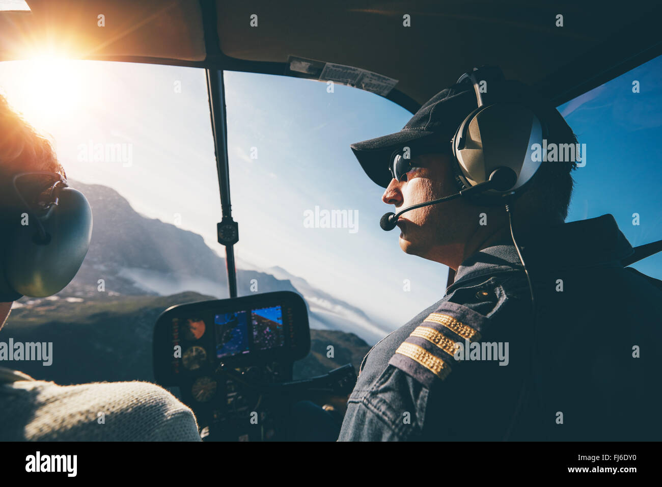 Mann und Frau-Piloten fliegen eines Hubschraubers an einem sonnigen Tag. Im inneren Aufnahme eines Hubschraubers. Stockfoto