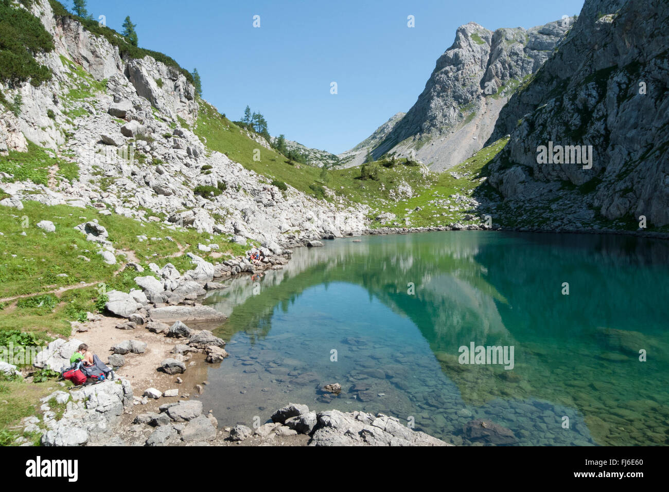 Wanderer ruht auf See Seleinsee in den Bergen des Nationalparks Berchtesgaden an einem sonnigen Sommertag, Bayern, Deutschland Stockfoto