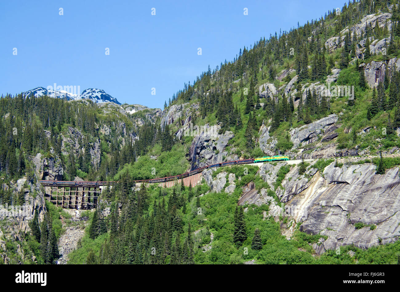 White Pass & Yukon Route Railroad reist entlang der Klippen nach dem Verlassen der Tunnel Mountain Stockfoto