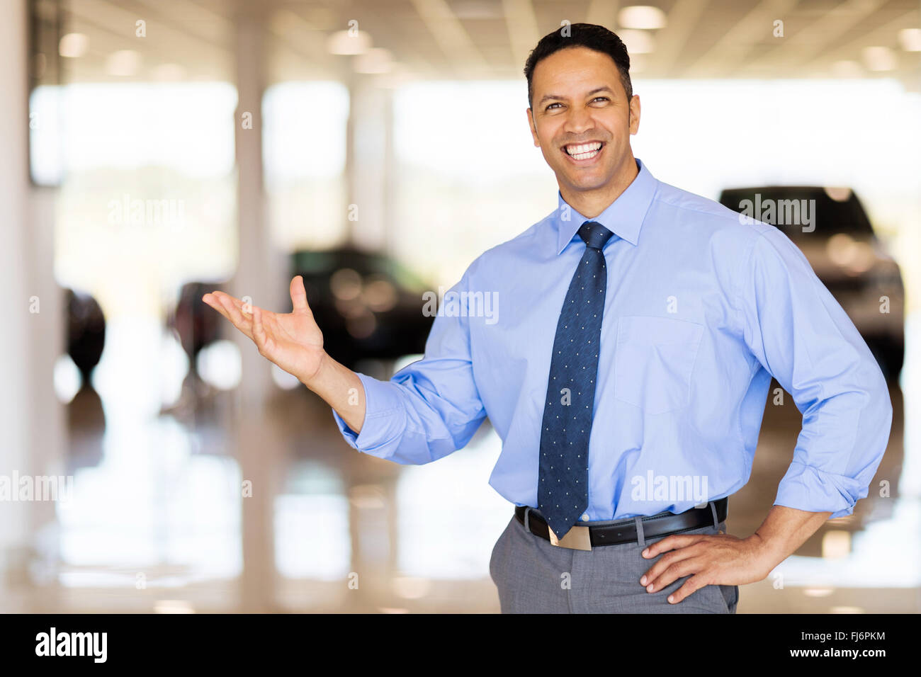 freundlichen Fahrzeug Verkäufer Neuwagen im Showroom präsentiert Stockfoto