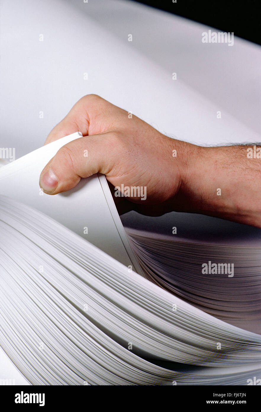 Pressman inspiziert große Bogen Druckpapier Stockfoto