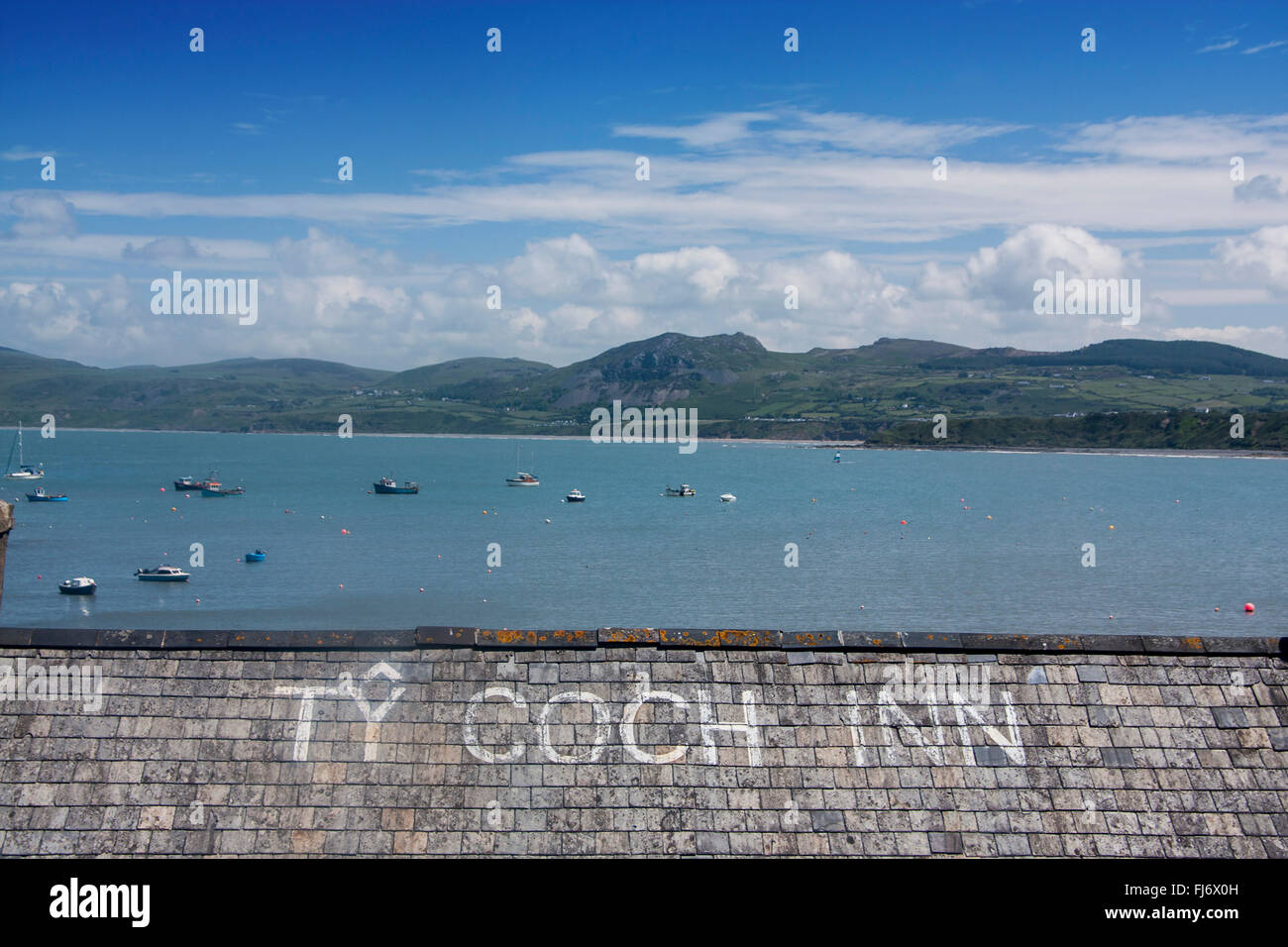Porth Dinllaen Ty Coch Inn Pub Schiefer geflieste Dach und Blick über Hafen, Boote und Berge Cardigan Halbinsel Gwynedd North Wales UK Stockfoto
