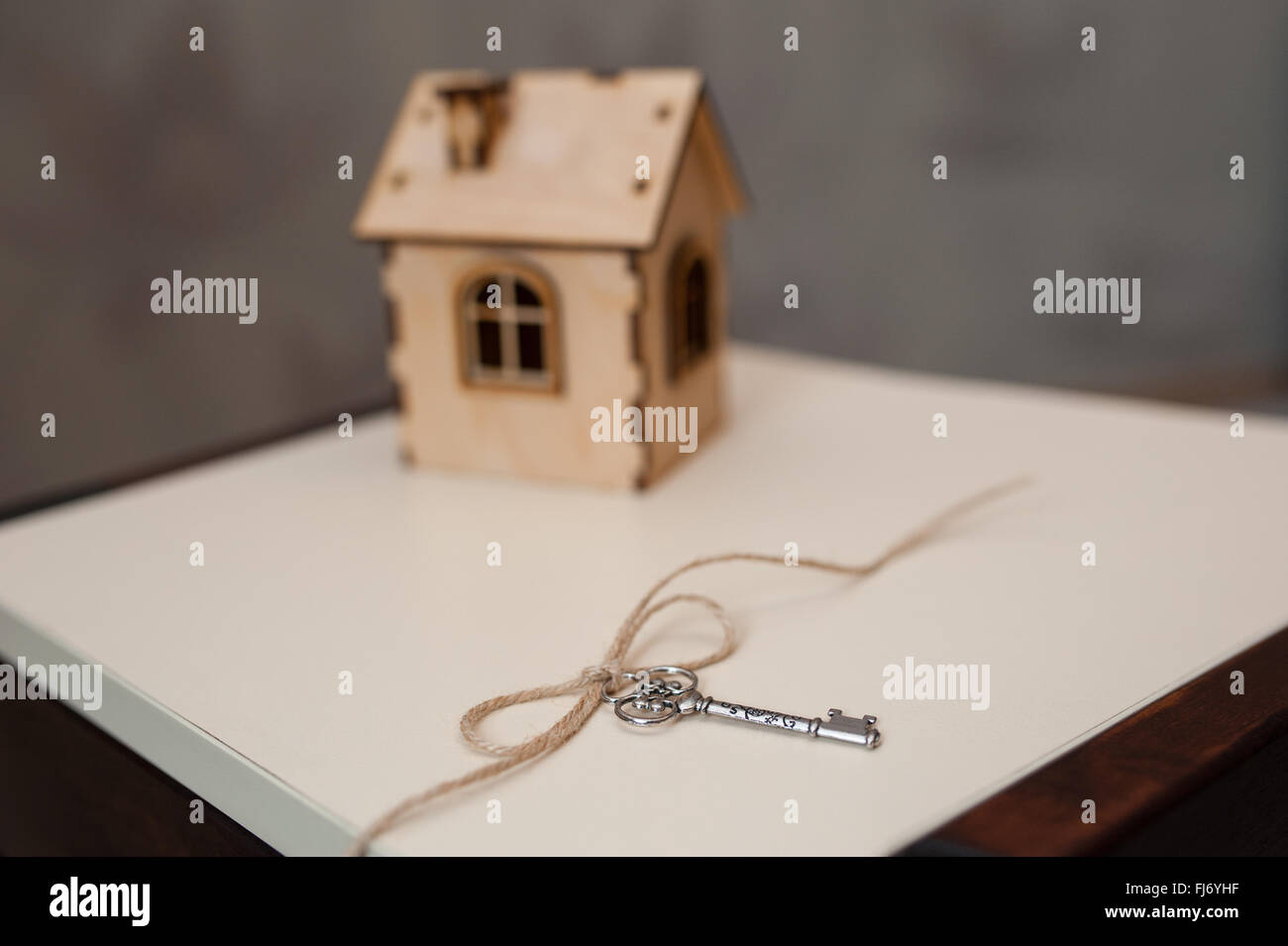 Konzeptbild mit kleinen Holzhaus und Schlüsseln. Stockfoto