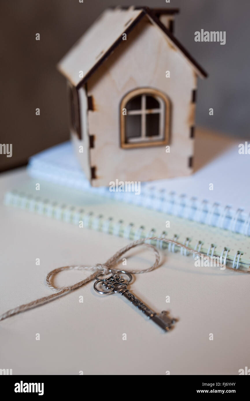 Konzeptbild mit kleinen Holzhaus und Schlüsseln. Stockfoto