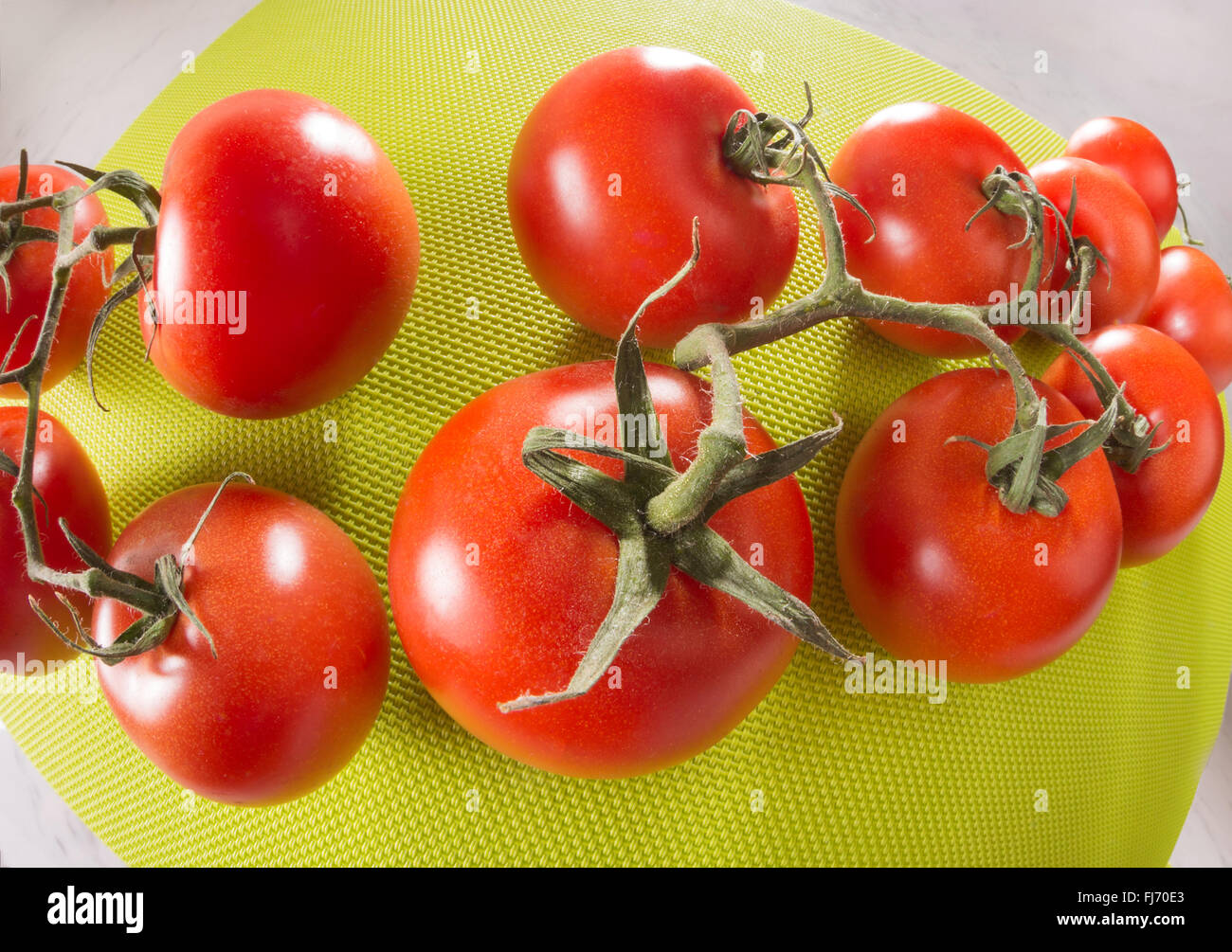 Tomaten auf einem grünen Hintergrund, fisheye-Objektiv, Weitwinkel Verzeichnung des Objektivs weit, riesige Runde rot-grün, glänzend, frisch mit Stielen, bu Stockfoto