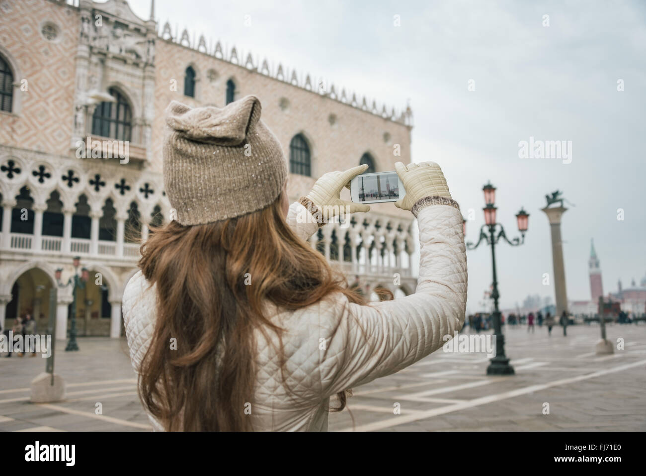 Reizvolle Venedig kann helfen, das Beste aus Ihrem nächsten Winterurlaub machen. Gesehen von hinten junge Frau Touristen fotografieren Stockfoto