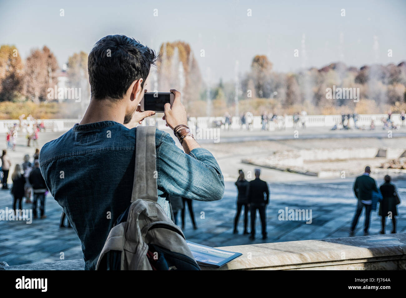 Eine halbe Stelle erschossen von ein nachdenklich hübscher junger Mann, ein Tourist hält eine Anleitung suchen Weg außen Altbau in Europea Stockfoto