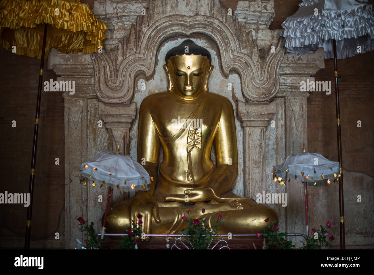 Gautama Buddha Statue Htilominlo Tempel Nyaung-U Myanmar // NYAUNG-U, Myanmar – Eine goldene Statue von Gautama Buddha steht im Htilominlo Tempel, einem der prominenten buddhistischen Tempel in der antiken Stadt Bagan. Der Tempel Htilominlo wurde Anfang des 13. Jahrhunderts während der Regierungszeit von König Htilominlo erbaut und repräsentiert den architektonischen Stil der späten Bagan-Zeit. Der Tempel ist bekannt für seine gut erhaltenen Fresken und mehrere Buddha-Bilder, die in seinen Innenräumen untergebracht sind. Nyaung-U dient als Tor zur archäologischen Zone Bagan, die Tausende von buddhistischen Tempeln beherbergt Stockfoto