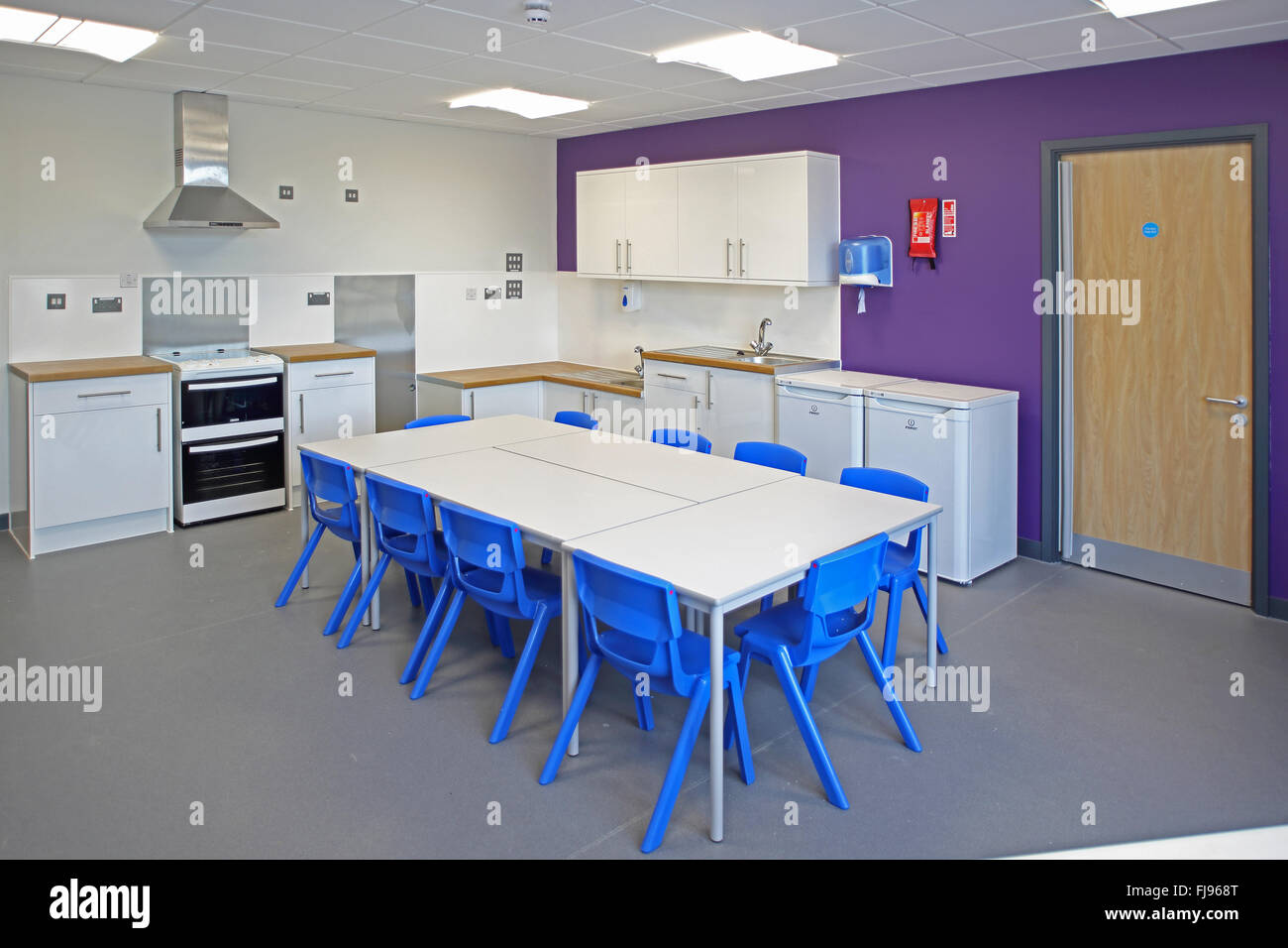 Ein Hauswirtschaft Klassenzimmer in eine neue britische Grundschule. Zeigt Tabelle, Herde und Waschmaschinen Stockfoto