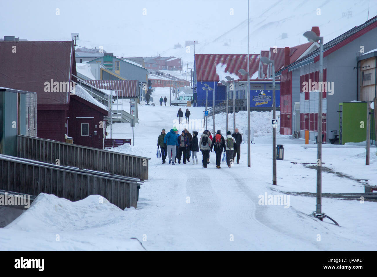 Menschen an der Hauptstraße in Longyearbyen, Norwegen, Spitzbergen (Svalbard). März, noch viel Schnee. Stockfoto
