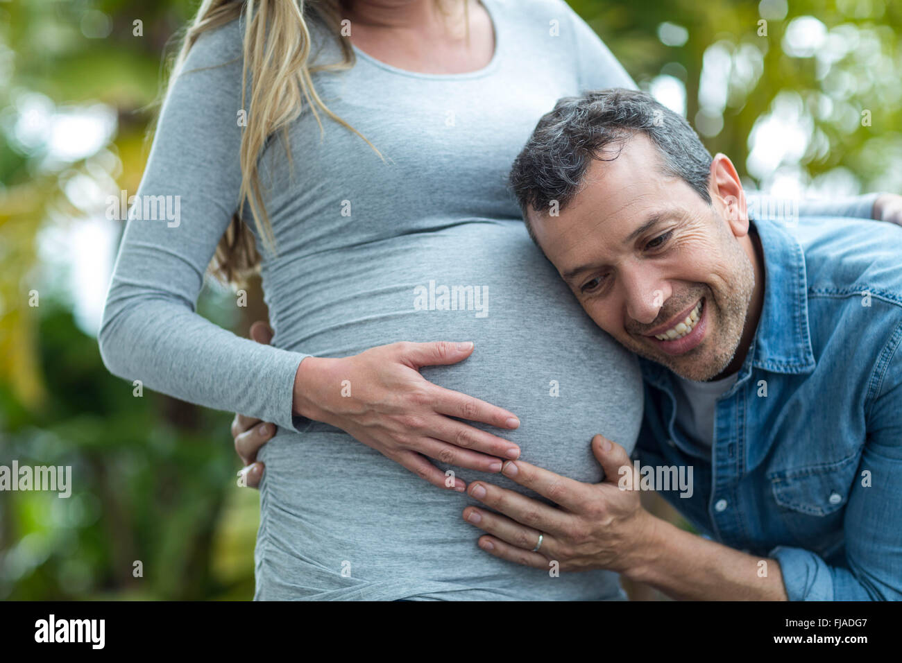 Mann schwanger Womans Magen anhören Stockfoto