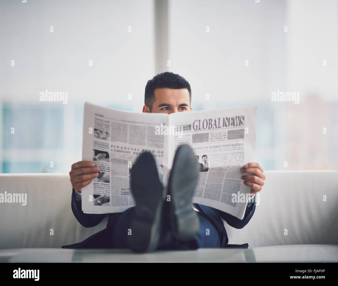 Zeitgenössischen Geschäftsmann Zeitunglesen im Büro Stockfoto