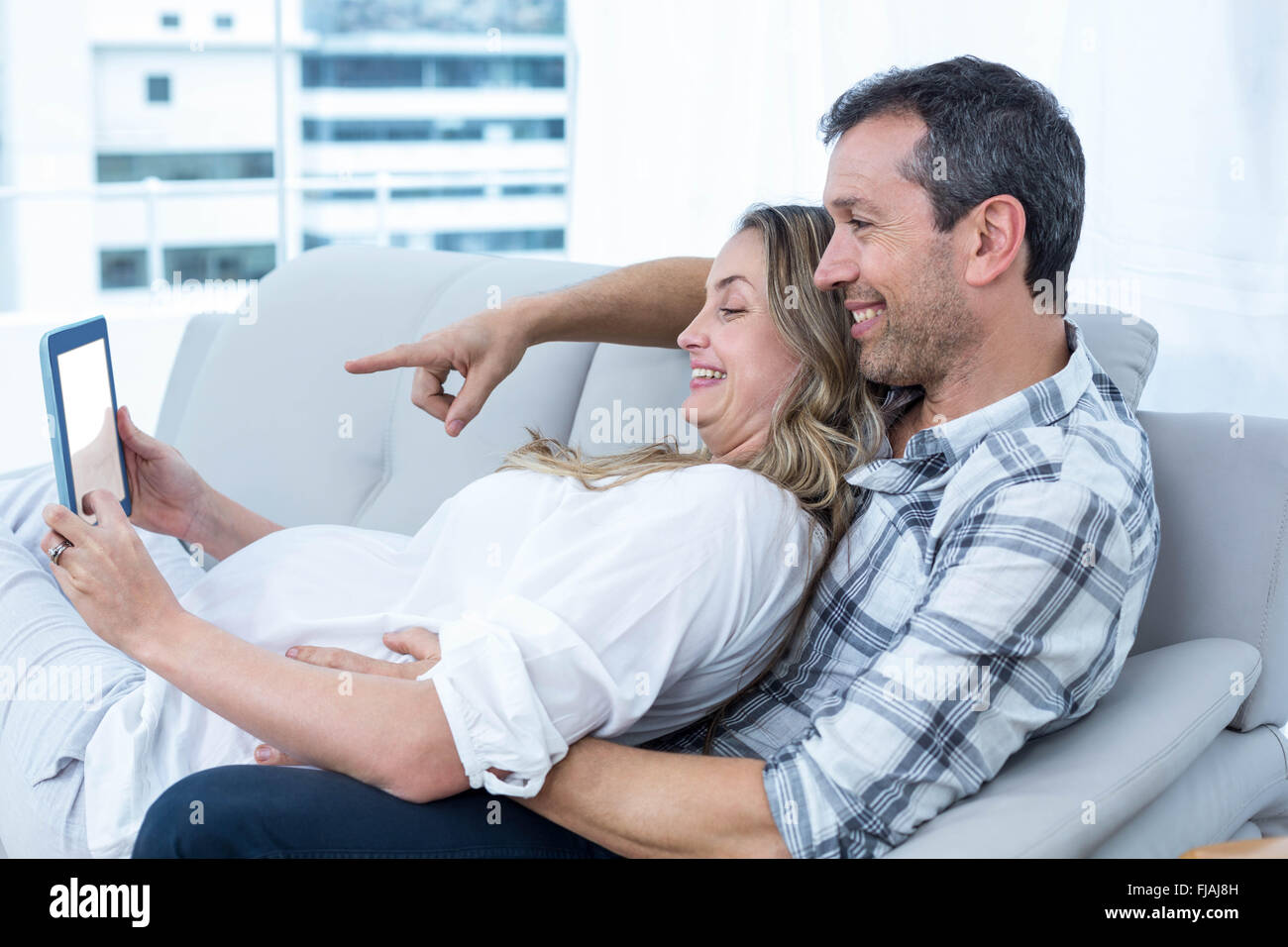 Werdende Paar auf sofa Stockfoto