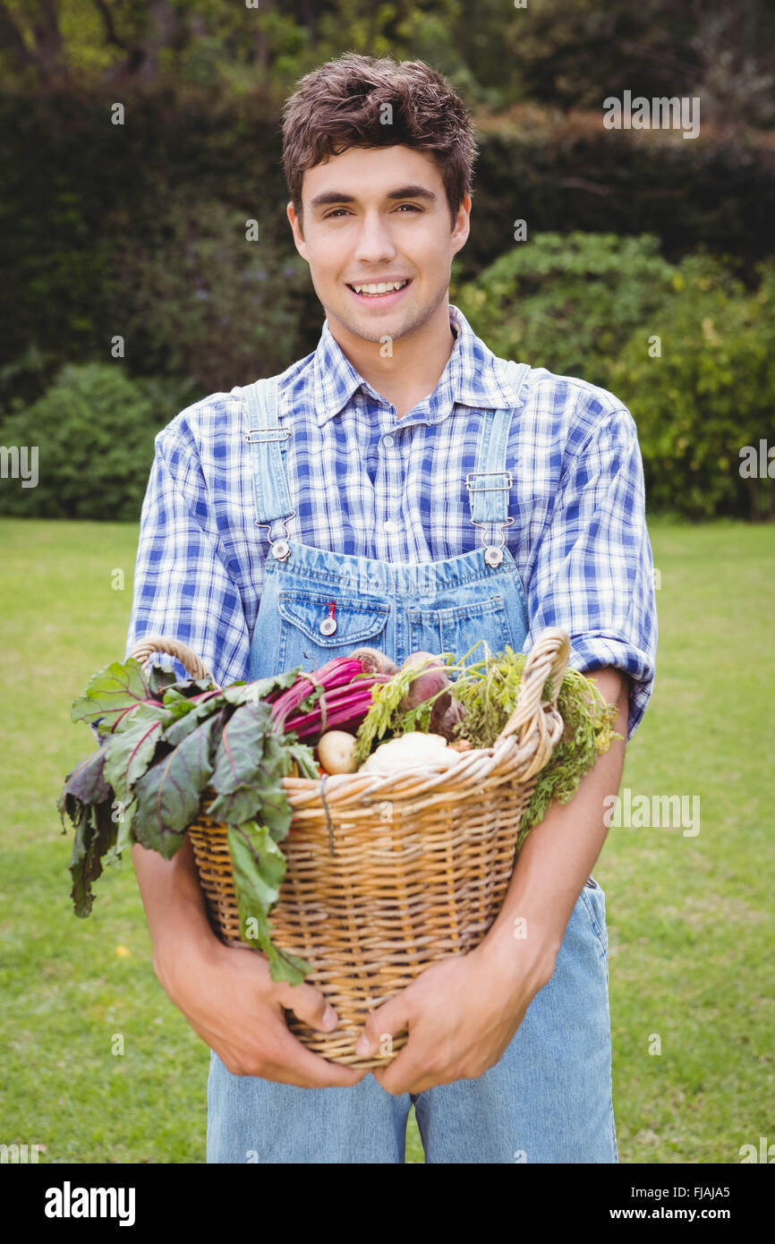 Mann hält einen Korb mit frisch geernteten Gemüse Stockfoto