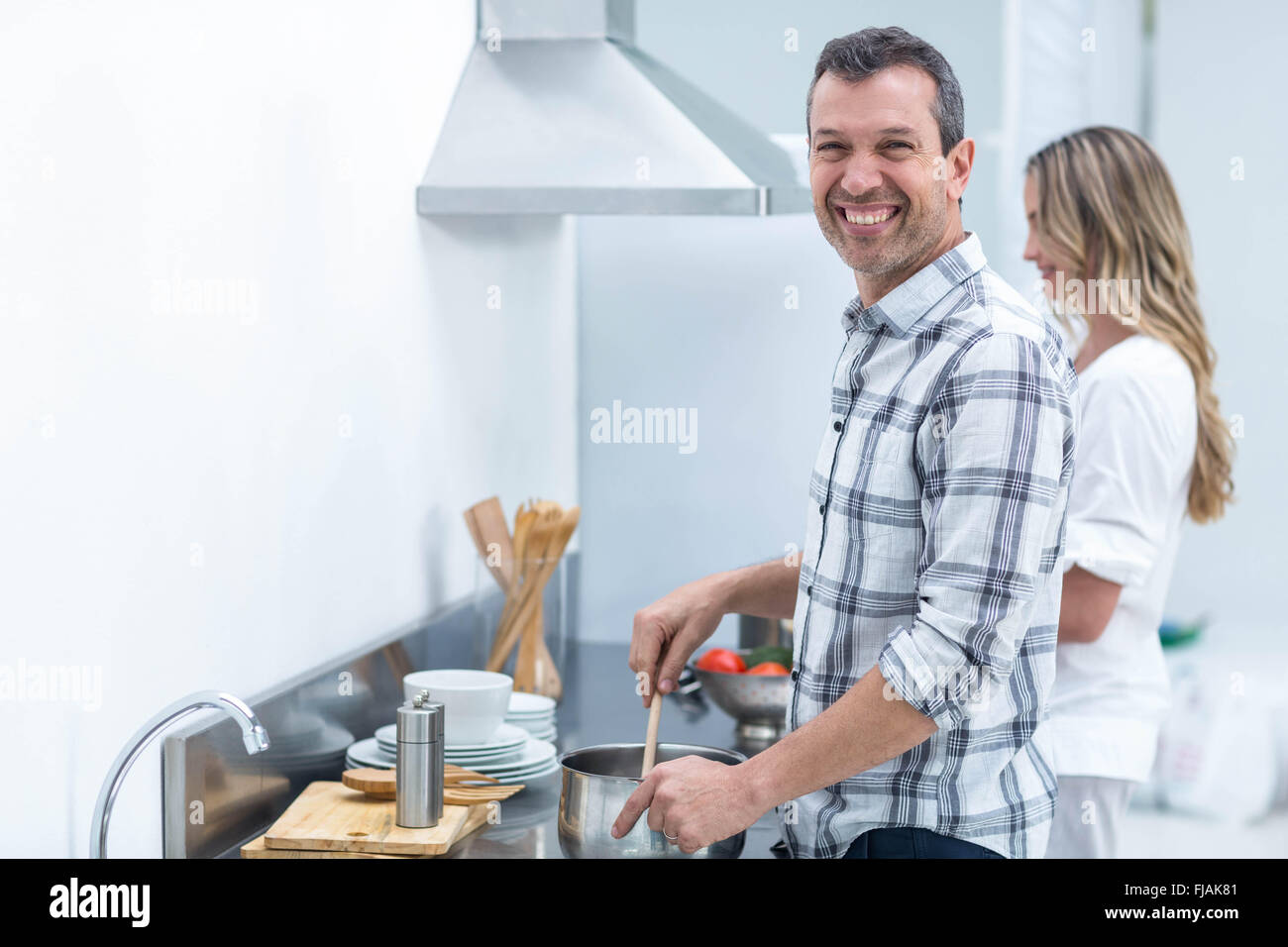 Mann hilft schwangeren Frau Essen zubereiten Stockfoto