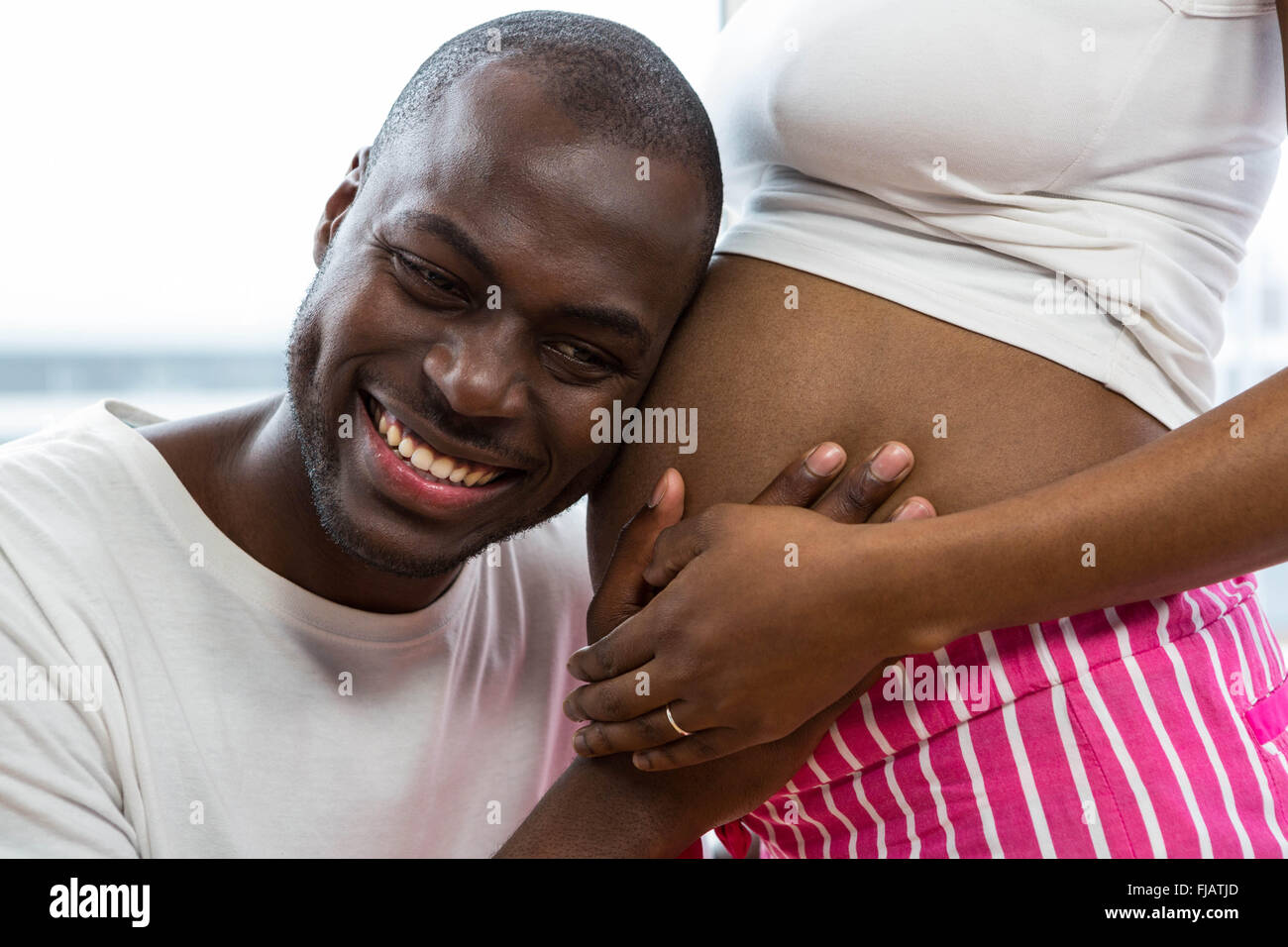 Mann schwanger Womans Magen anhören Stockfoto