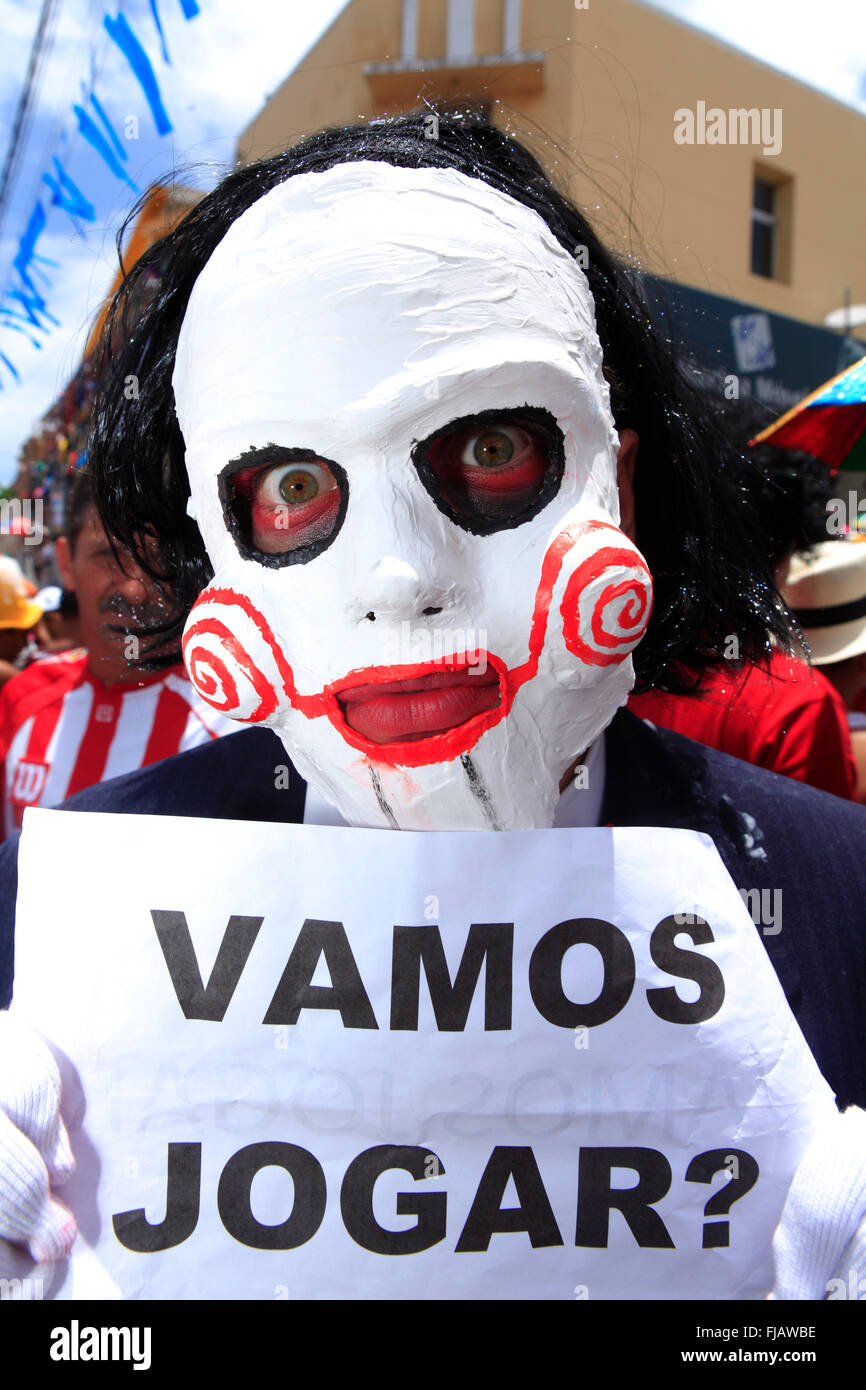 Mann in einer Karnevalsmaske in Brasilien - das Zeichen sagt "Lasst uns spielen" Stockfoto