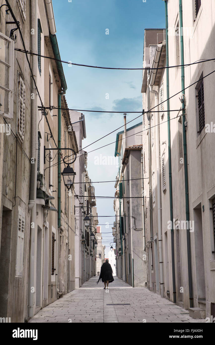 Europa, Kroatien, Dalmatien, Insel Pag, Stadt Pag, Eine Witwe, die eine leere Wohnstraße entlang läuft Stockfoto