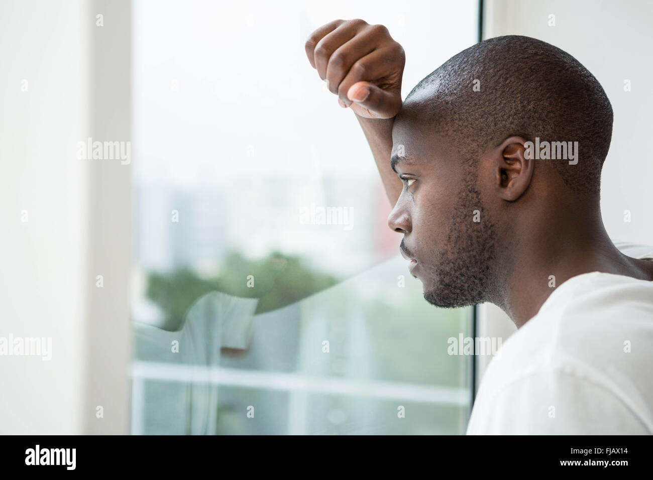 Nachdenklicher Mann schaut aus dem Fenster Stockfoto