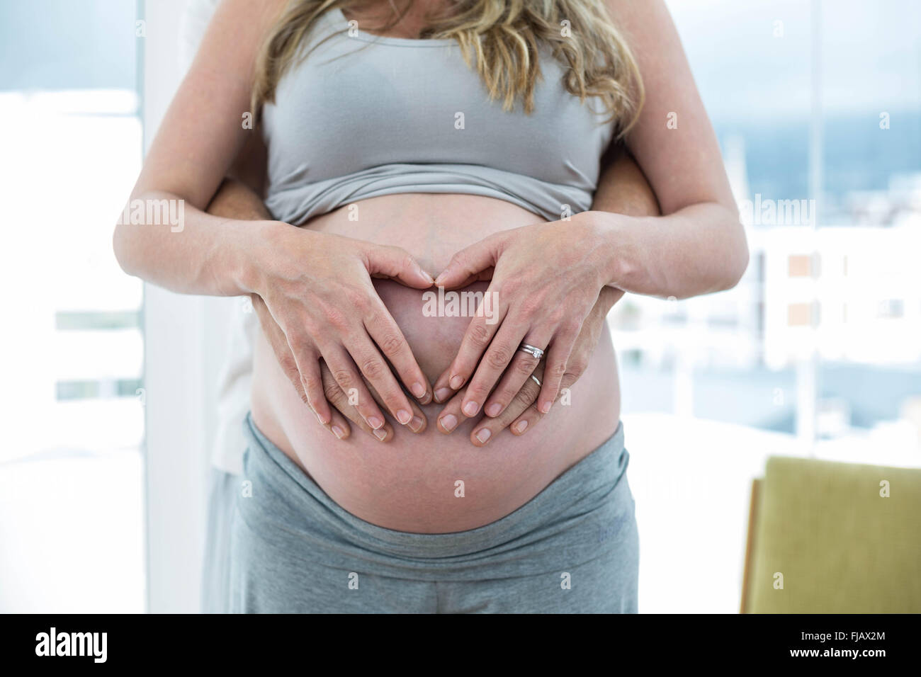 Mann halten schwanger Womans Magen Stockfoto
