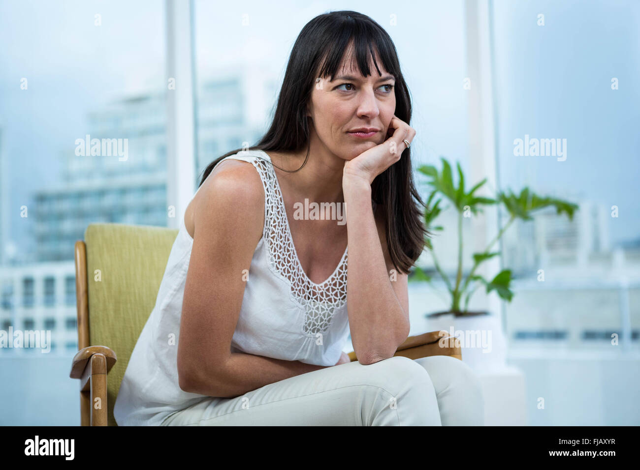Schwangere Frau sitzt deprimiert Stockfoto