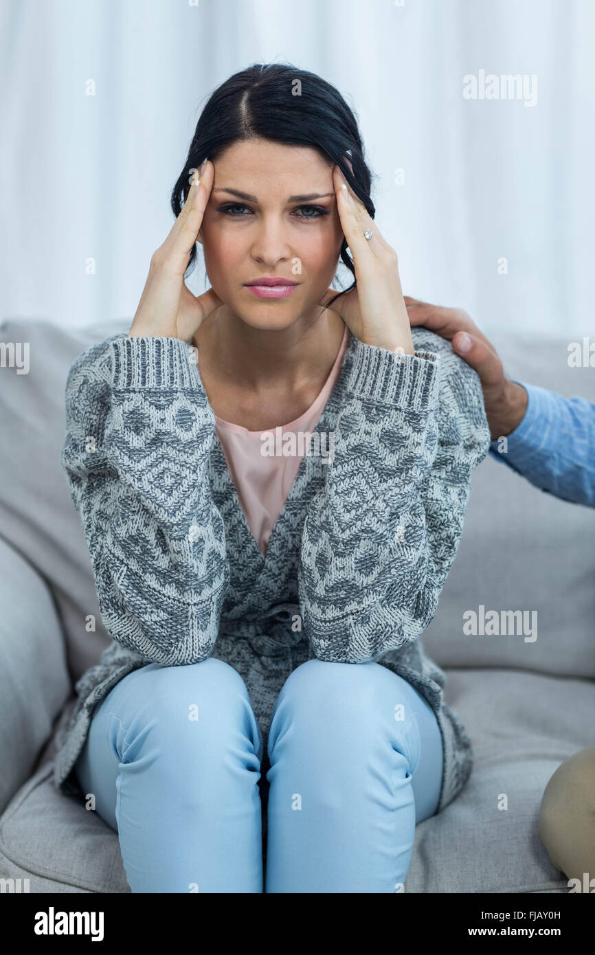Besorgt schwangere Frau auf dem Sofa sitzen Stockfoto