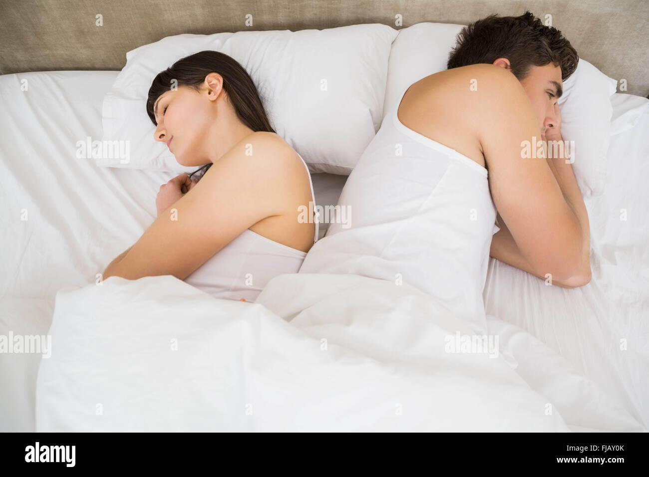 Paar schlafen Rücken an Rücken nach einem Streit Stockfoto