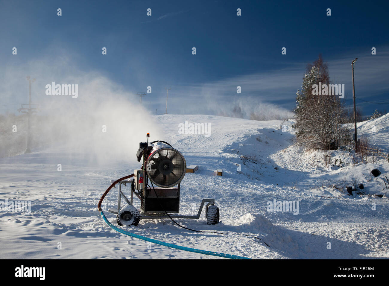 Maschine macht Schnee auf der Piste Stockfoto